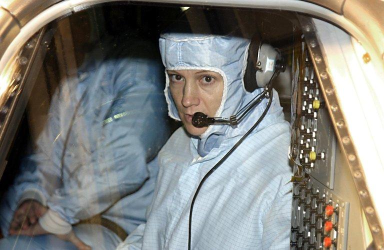 KENNEDY SPACE CENTER, FLA. - STS-114 Commander Eileen Collins (foreground) checks out the windshield in Atlantis. She and other crew members are at KSC to take part in Crew Equipment Interface Test activities, which include checking out the payload and orbiter. STS-114 is a utilization and logistics flight (ULF-1) that will carry Multi-Purpose Logistics Module Raffaello and the External Stowage Platform (ESP-2), as well as the Expedition 7 crew, to the International Space Station. Launch is targeted for March 1, 2003.