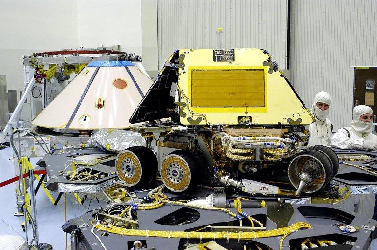 KENNEDY SPACE CENTER, FLA. -- In the Payload Hazardous Servicing Facility, technicians prepare to close the lander petals and attached airbags of the Mars Exploration Rover 2 (MER-2) around the spacecraft prior to launch. The MER Mission consists of two identical rovers set to launch in Spring 2003. Landing at different regions of Mars, they are designed to cover roughly 110 yards each Martian day over various terrain. Each rover will carry five scientific instruments that will allow it to search for evidence of liquid water that may have been present in the planet's past.