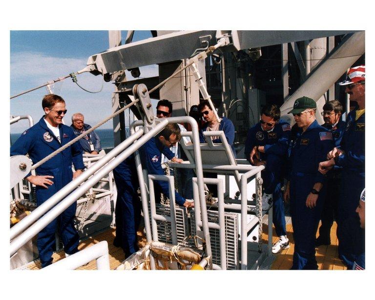 KENNEDY SPACE CENTER, Fla. --STS-82 crew members and other onlookers at Launch Pad 39A watch as STS-82 Mission Specialist Steven L. Smith becomes familiar with operation of the slidewire baskets. The slidewire baskets are part of the emergency egress system at the pad. The crew are at KSC to participate in the Terminal Countdown Demonstration Test (TCDT), a dress rehearsal for launch. In their blue flight suits, from left, are Payload Commander Mark C. Lee, Smith, Mission Specialist Gregory J. Harbaugh, Mission Commander Kenneth D. Bowersox and Mission Specialist Joseph R. "Joe" Tanner. The seven-member STS-82 crew will conduct the second Hubble Space Telescope servicing mission. Liftoff of the 10-day flight is scheduled Feb. 11