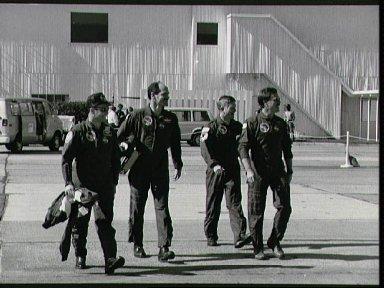 STS-27 crewmembers walk across parking apron to T-38s at Ellington Field